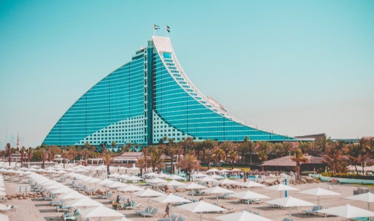 Jumeirah Beach Hotel wave-shaped building behind a beach of umbrellas
