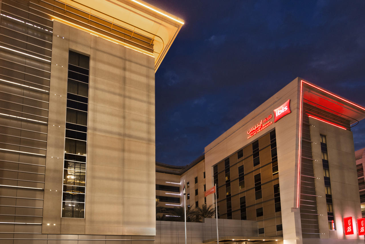 ibis Mall of the Emirates hotel exterior at night with red ibis signage