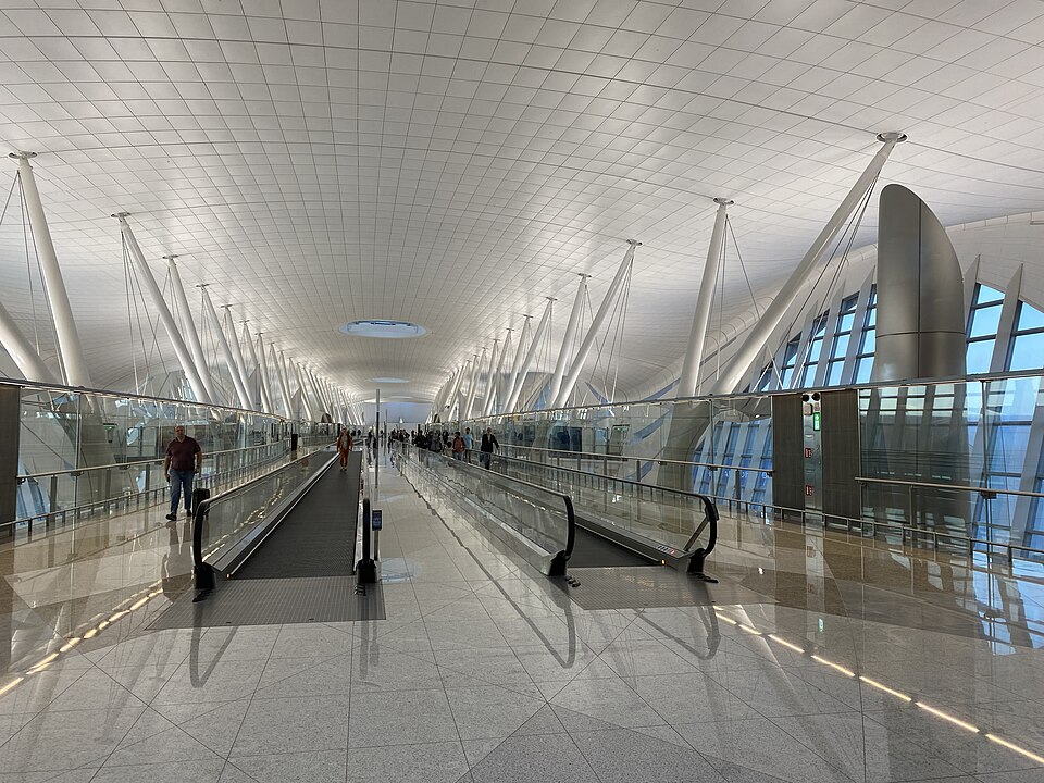 Long concourse with moving walkways inside Zayed International Airport Terminal A
